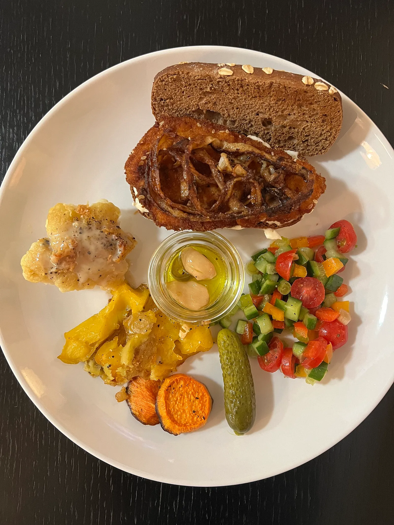 צלחת אוכל ביתי ישראלי עם כריך שניצל, ירקות אפויים, סלט ירקות טרי ומלפפון חמוץ, כמו במסעדה הכשרה בקופנגן