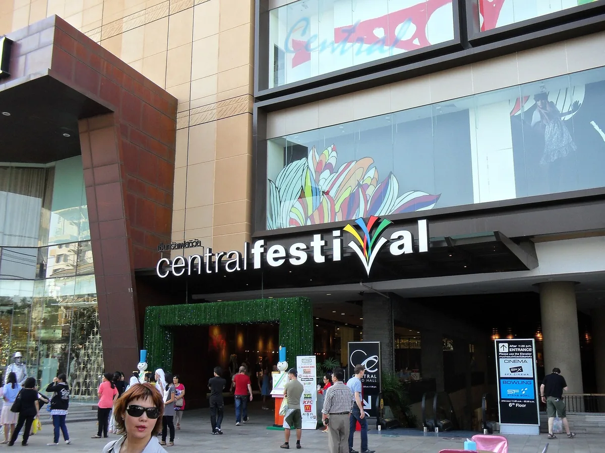כניסה ראשית של מרכז קניות עם שילוט גדול וקונים נכנסים